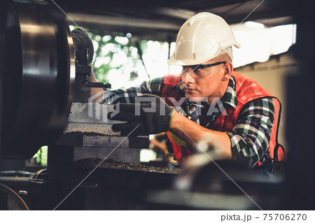 Smart factory worker or engineer do machine job in a manufacturing workshop 75706270