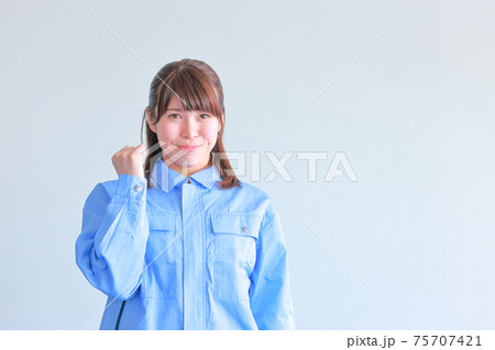 作業スタッフの女性_控えめな笑顔でガッツポーズ 75707421