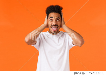 Annoyed and irritated african-american male arguing, complaining noisy neighbours in dormitory, cant study, cover ears, shouting look up displeased and angry, standing orange background Annoyed and irritated african-american male arguing, complaining noisy neighbours in dormitory, cant study, cover ears, shouting look up displeased and angry, standing orange background 75711880