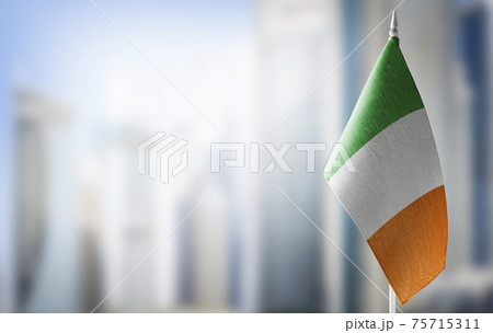 A small flag of Ireland on the background of a blurred background A small flag of Ireland on the background of a blurred background 75715311