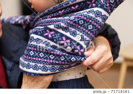 子供を着替えさせるシニア 75718161