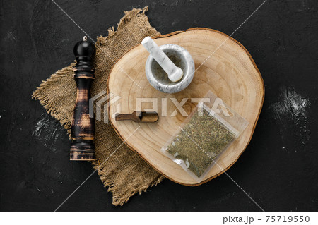Wooden cross section with Provencal herbs in plastic package and mortar and mill 75719550