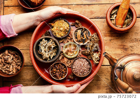 Medicinal healing herbs on tray in hands Medicinal healing herbs on tray in hands 75723072