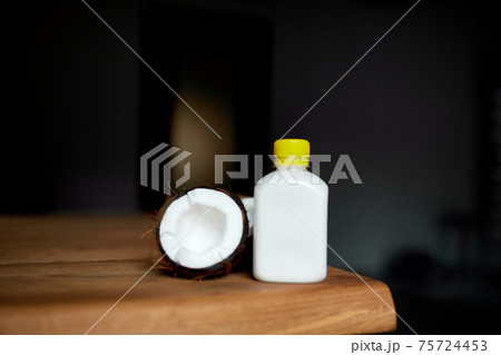 Fresh healthy coconut milk in a glass on wooden table background Fresh healthy coconut milk in a glass on wooden table background 75724453