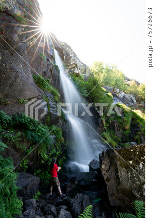Unrecognizable person under the waterfall, long exposure 75726673