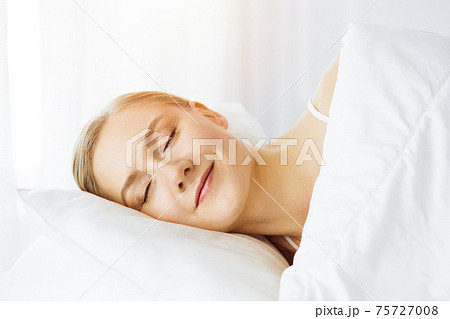 Beautiful young woman sleeping in bedroom comfortably and blissfully Beautiful young woman sleeping in bedroom comfortably and blissfully 75727008