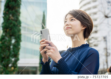 街でスマホを使う女性 街でスマホを使う女性 75727705