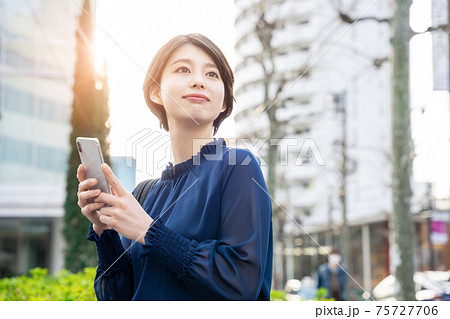 街でスマホを使う女性 75727706