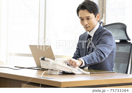 ビジネス 企業 電話を取る男性 ビジネス 企業 電話を取る男性 75733164