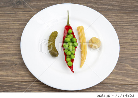 salad of pickled and pickled corn, peas, cucumber and red pepper on a white plate. salad of pickled and pickled corn, peas, cucumber and red pepper on a white plate. 75734852