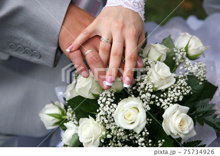 hands of bride and groom near wedding bouquet hands of bride and groom near wedding bouquet 75734926