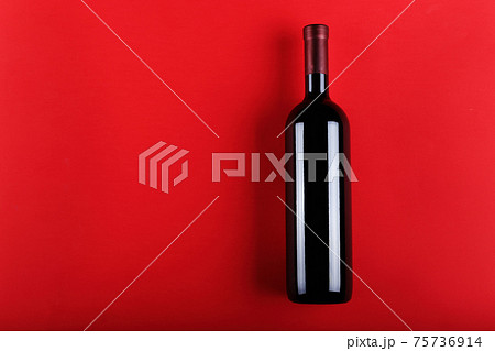 Wine bottle on a red paper background. 75736914