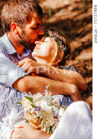 Eclectic wedding couple sitting and hugging on the bench 75737868