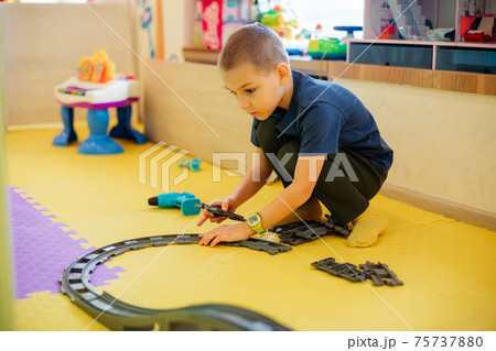 The cute child is playing with toy cars at home The cute child is playing with toy cars at home 75737880
