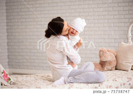 Mother, playing with her toddler boy smiling. 75738747