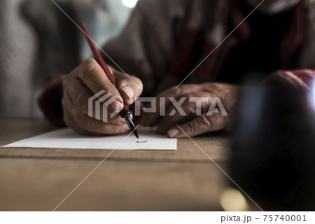 A man with dirty hands writing on a sheet of paper A man with dirty hands writing on a sheet of paper 75740001