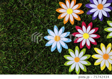 Images of flowers made of colorful felt fabrics. Isolated on the artificial grass. Images of flowers made of colorful felt fabrics. Isolated on the artificial grass. 75742434