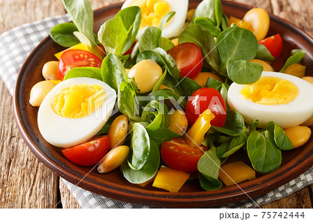Breakfast of boiled eggs and salad of lupine beans, tomatoes and common cornsalad close-up in a plate. horizontal Breakfast of boiled eggs and salad of lupine beans, tomatoes and common cornsalad close-up in a plate. horizontal 75742444