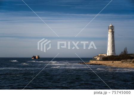Lone beacon guards the ships. The lighthouse shows the way for boats. Wrecked ship lays nearby Lone beacon guards the ships. The lighthouse shows the way for boats. Wrecked ship lays nearby 75745000