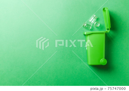 Trash recycle. Bin container for disposal garbage waste and save environment. Green dustbin for recycle glass can trash isolated on green background. Trash recycle. Bin container for disposal garbage waste and save environment. Green dustbin for recycle glass can trash isolated on green background. 75747000