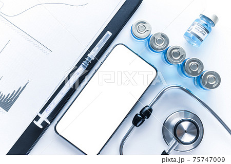 Medical application. Hospital equipment: doctor stethoscope, healthcare charts, syringe with needle and black smartphone with blank screen. Mockup generic device. Medical application. Hospital equipment: doctor stethoscope, healthcare charts, syringe with needle and black smartphone with blank screen. Mockup generic device. 75747009