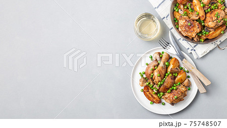 Chicken stew with potatoes, mushrooms and green peas, on a white plate and in metal pot, top view, horizontal, copy space Chicken stew with potatoes, mushrooms and green peas, on a white plate and in metal pot, top view, horizontal, copy space 75748507