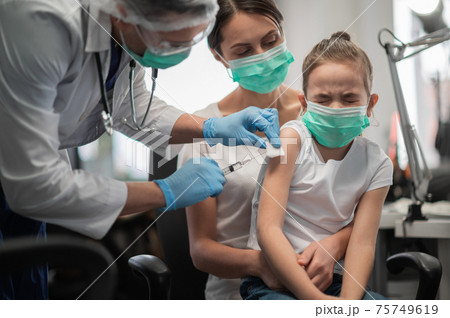 A caring mother brought her daughter to the vaccination office to get vaccinated, the girl is afraid A caring mother brought her daughter to the vaccination office to get vaccinated, the girl is afraid 75749619
