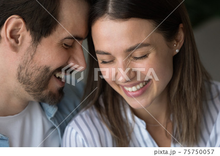 Close up happy man and woman touching foreheads, expressing love Close up happy man and woman touching foreheads, expressing love 75750057