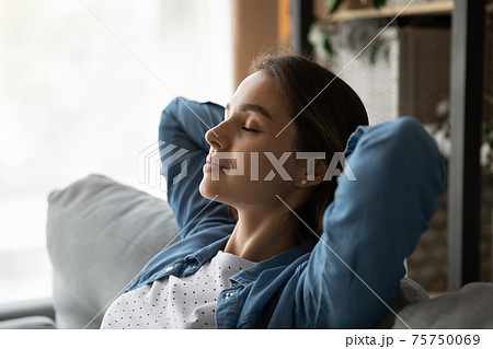 Close up calm woman with closed eyes resting on couch 75750069