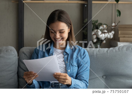 Close up smiling woman reading good news in letter 75750107