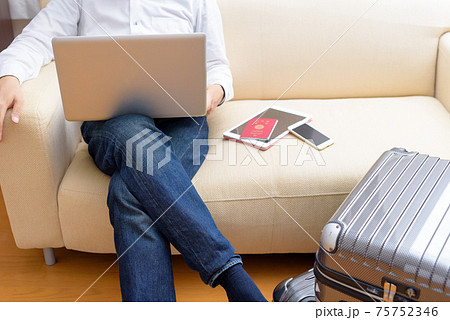 旅行の準備　旅行先でノートパソコンを使う男性 75752346