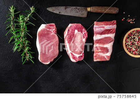 Pork meat, various cuts, shot from above on a black background Pork meat, various cuts, shot from above on a black background 75758645