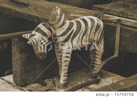 The damaged statue of zebra with a falling head, close up.The variant in a sepia tone with dust. 75759758