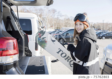 車のトランクからスノーボードを出す若い女性 ウィンタースポーツ 車のトランクからスノーボードを出す若い女性 ウィンタースポーツ 75762803