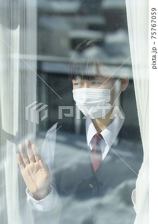 窓から外を見る中学生（外出自粛要請のイメージ） 75767059