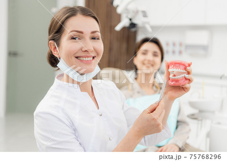 Healthy, beautiful smile. A portrait of a doctor holding an arti 75768296