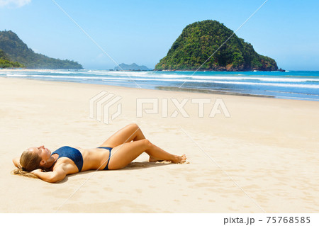 Happy young woman relax on tropical sand beach 75768585