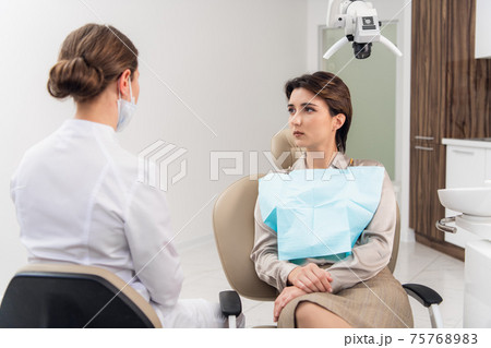 A young female dentist consulting her patient 75768983