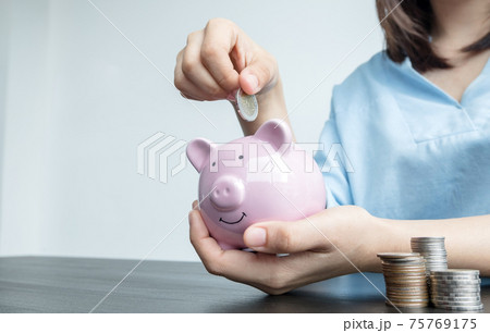 Women's hands are putting coins in the piggy bank Saving money with coins Step into a business that is growing to be successful and save for retirement ideas Women's hands are putting coins in the piggy bank Saving money with coins Step into a business that is growing to be successful and save for retirement ideas 75769175