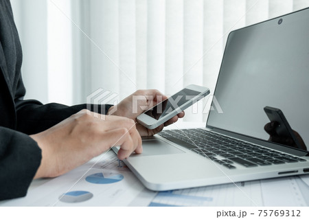 The hands of a male businesswoman are analyzing and calculating the annual income and expenses in a financial graph that shows results To summarize balances overall in office 75769312