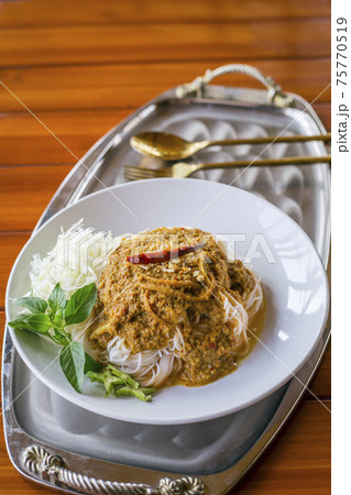 Rice noodles in fish curry sauce with vegetables on the table Rice noodles in fish curry sauce with vegetables on the table 75770519