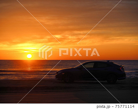 海へ沈む夕日と車 75771114