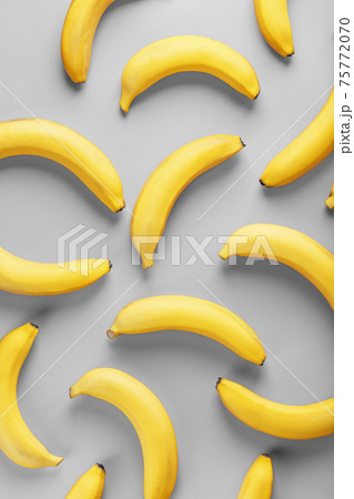 Geometric pattern of yellow bananas on a gray background in the Fashionable colors of 2021. 75772070