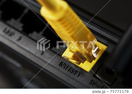 A yellow patch cord is inserted into the Wi-Fi port of the router to access the Internet. A yellow patch cord is inserted into the Wi-Fi port of the router to access the Internet. 75772179