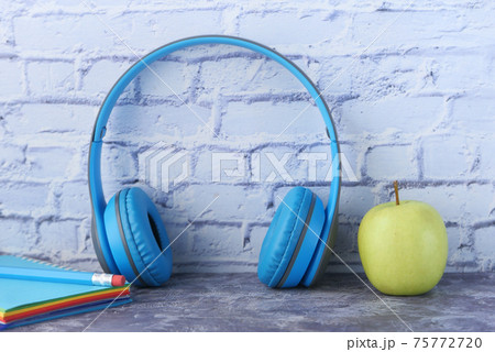 Audio book concept. Headphones and notepad on white background  75772720