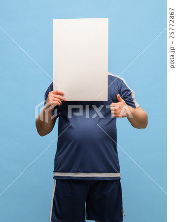 Young man in blue sports uniform with blank sign isolated on blue background. Young man in blue sports uniform with blank sign isolated on blue background. 75772867