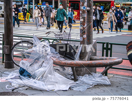 日本の東京都市景観　春の嵐の爪痕…。交差点脇には傘の山が…。宣言解除初日、多くの人出が…＝3月22日 75776041