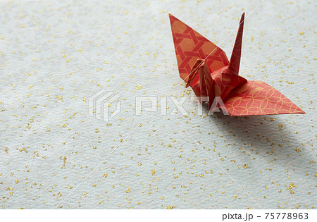 花柄と金の模様和紙の上の折り紙の鶴の写真素材