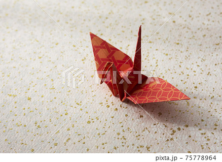 花柄と金の模様和紙の上の折り紙の鶴の写真素材