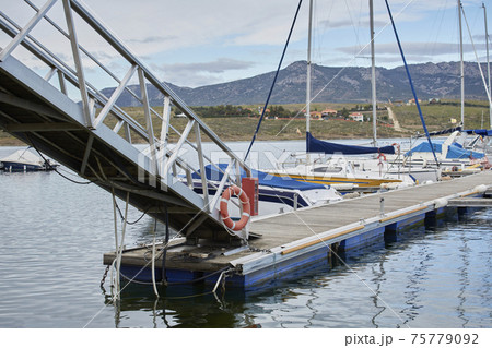 Footbridge or metal bridge to access the marina where fishing and pleasure boats are moored Footbridge or metal bridge to access the marina where fishing and pleasure boats are moored 75779092